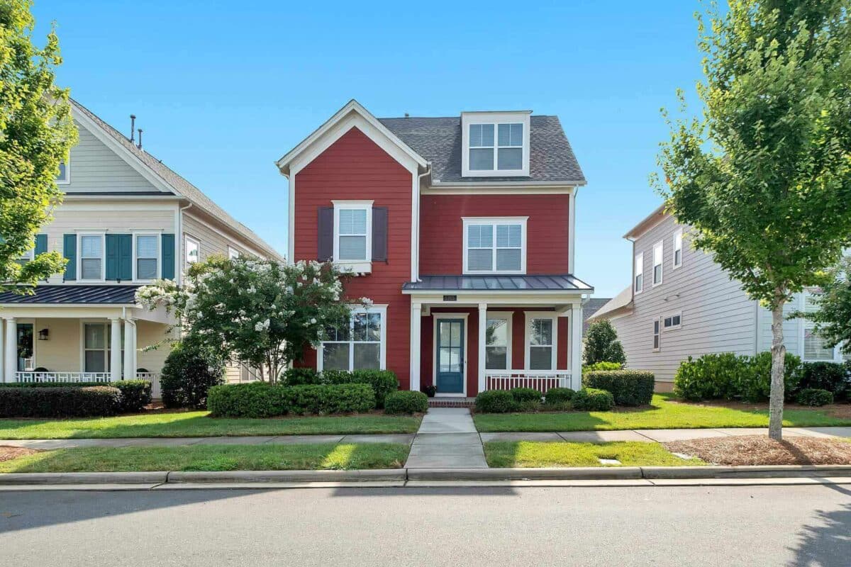 Red two-story house with a porch, symbolizing home equity loans for accessing funds through credit lines.