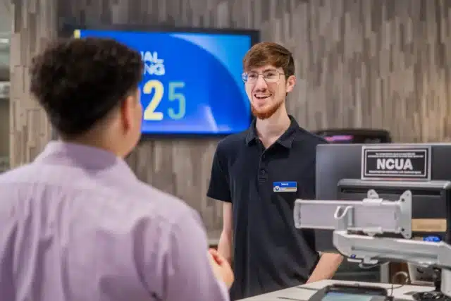 Bank employee assisting a customer at Greenville Federal Credit Union, showcasing personalized banking service.