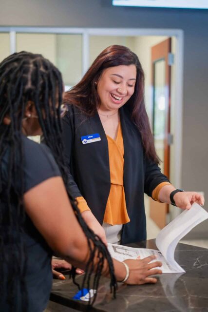 Credit union staff assisting a member with personalized banking services at Greenville branch.