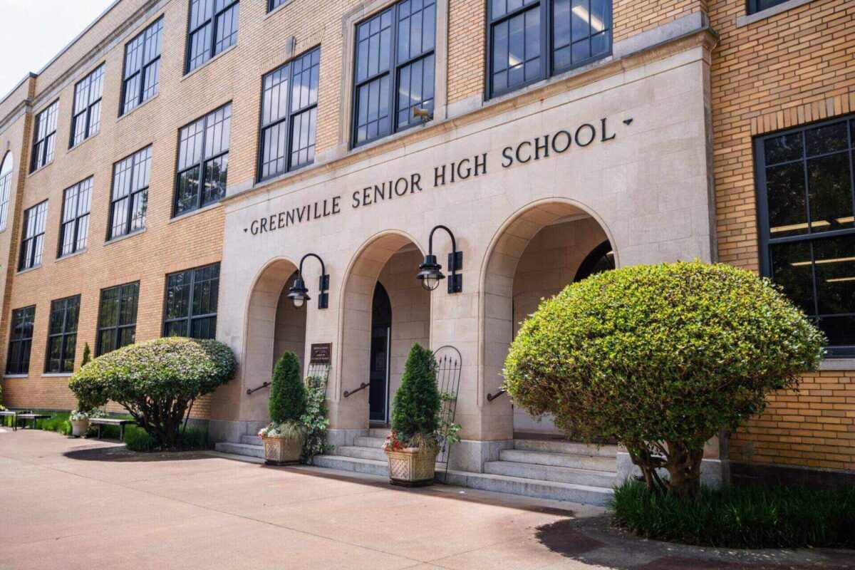 Greenville Senior High School entrance with arched doorways, brick facade, and greenery, symbolizing student empowerment through hands-on experiences.