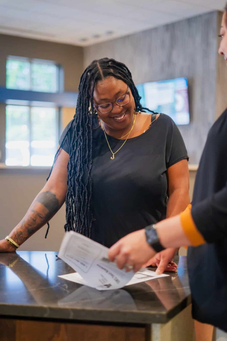 woman smiling down at paper in front of desk
