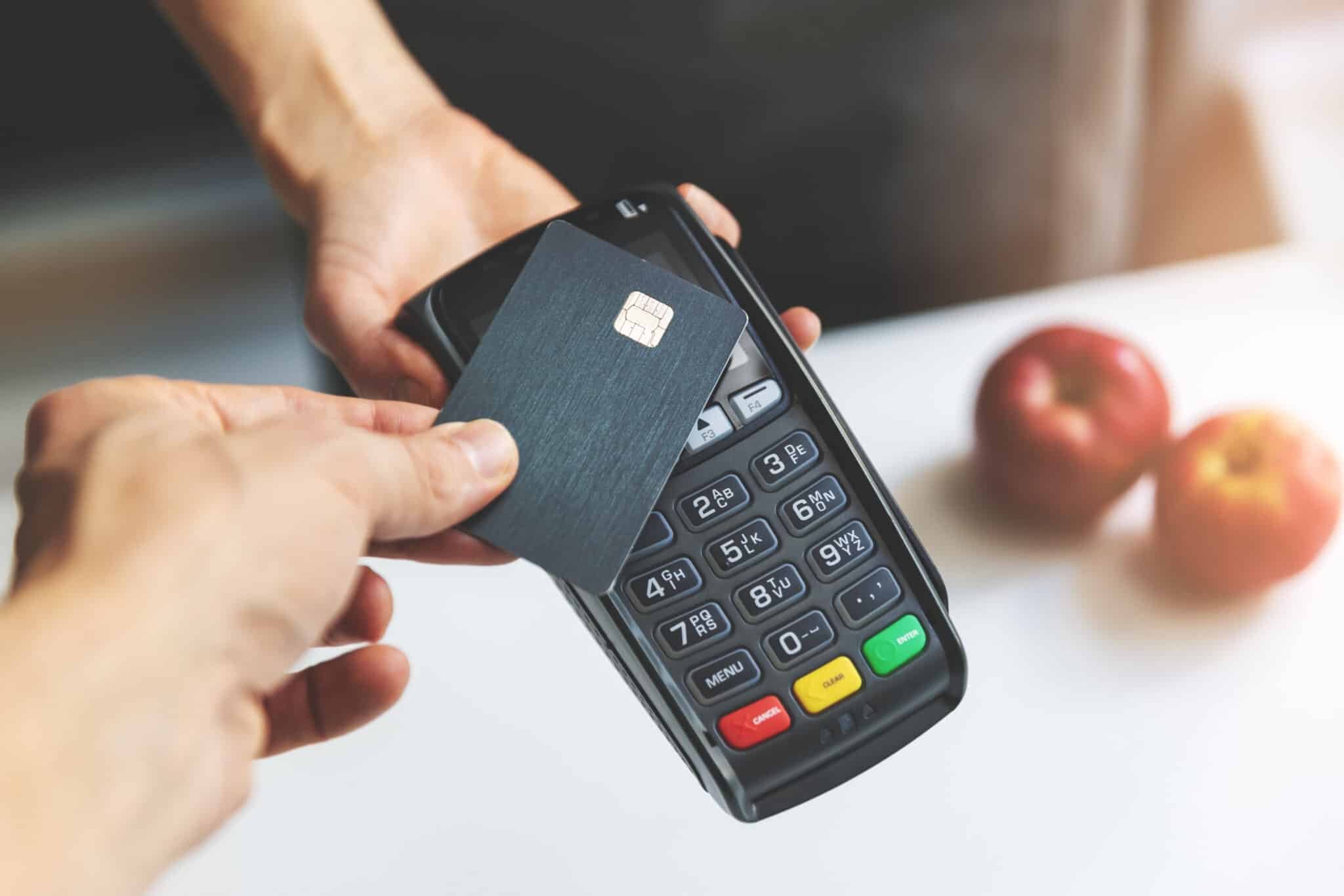 NFC contactless payment using a credit card at a POS terminal, streamlining payment processing solutions.