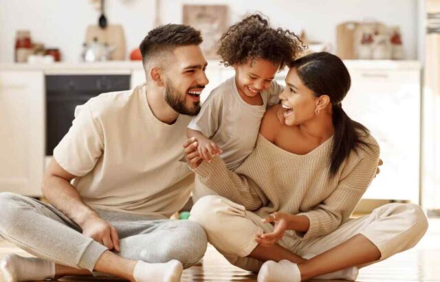Family laughing and playing on kitchen floor, symbolizing joy and security with Yield Plus Savings+ options.