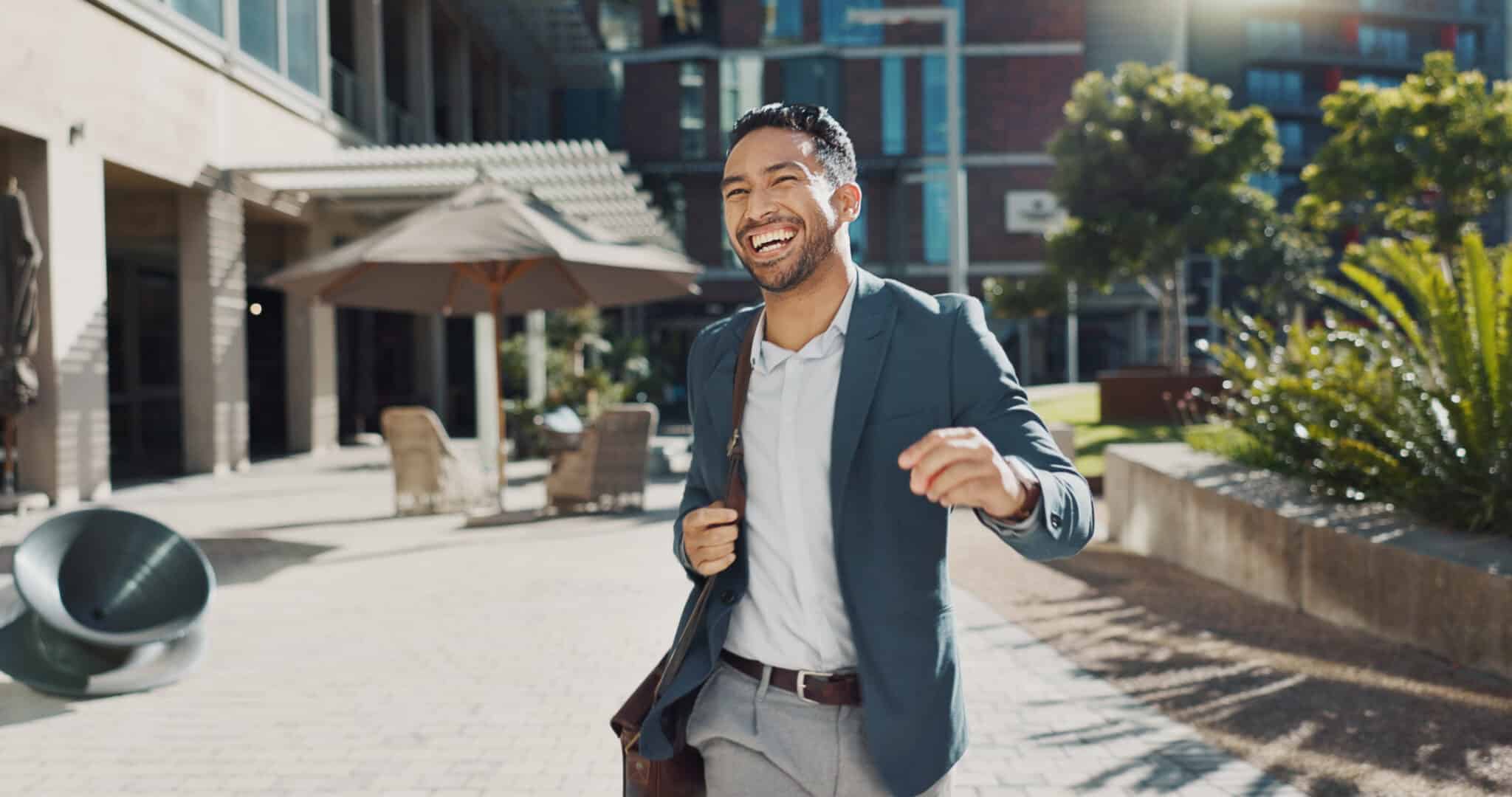Smiling man in a suit joyfully walking outside, embodying success and confidence, related to tailored overdraft protection.