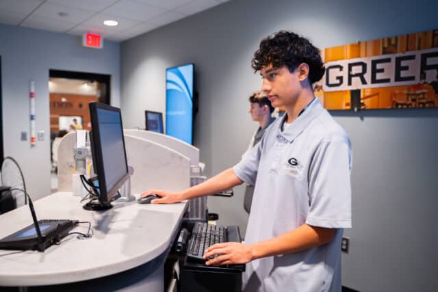 Student at Greer High working at a branch counter, gaining banking experience and enhancing financial skills.