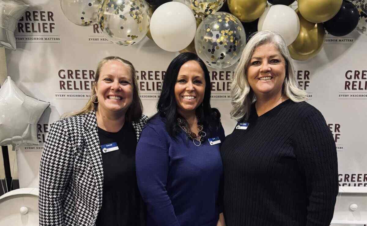 Three smiling team members from Greenville Federal Credit Union at a community event, embodying impact through financial services.