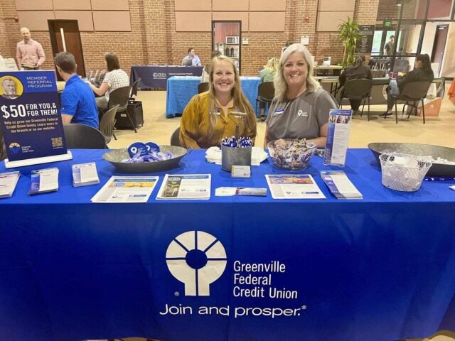 Greenville Federal Credit Union booth with staff showcasing partner program details to enhance employee well-being.
