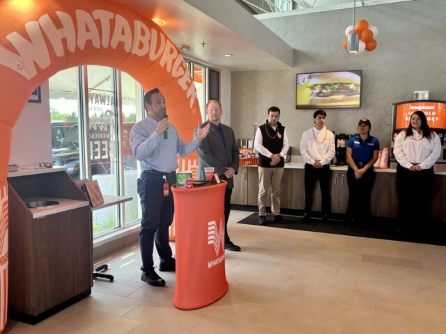 Whataburger event with speakers addressing the audience, highlighting company partner program benefits.