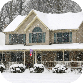 Snow-covered home with a porch and two stories, promoting Greenville Federal Credit Union's competitive loan offers.
