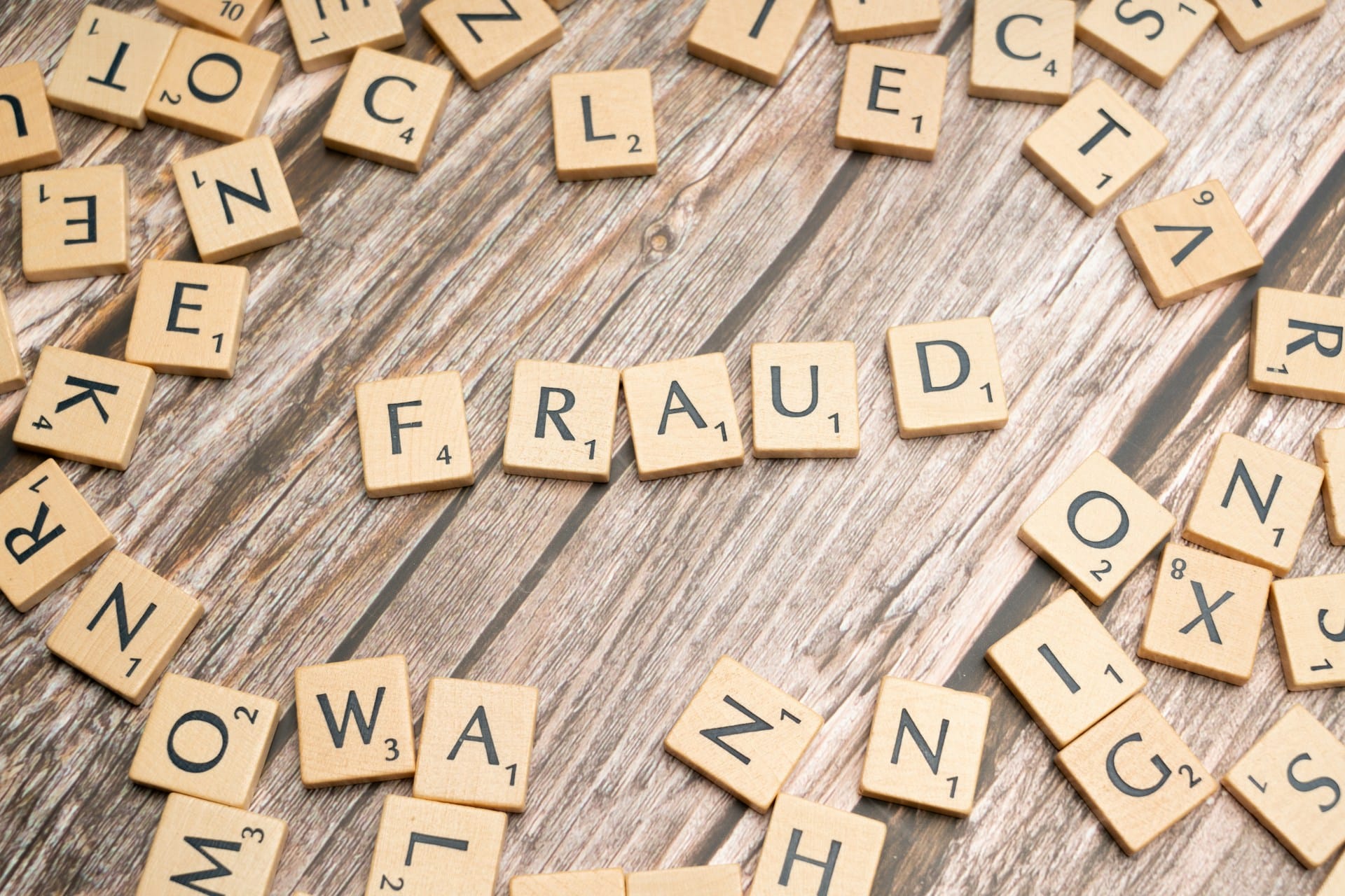 scrabble tile flat lay spelling out fraud